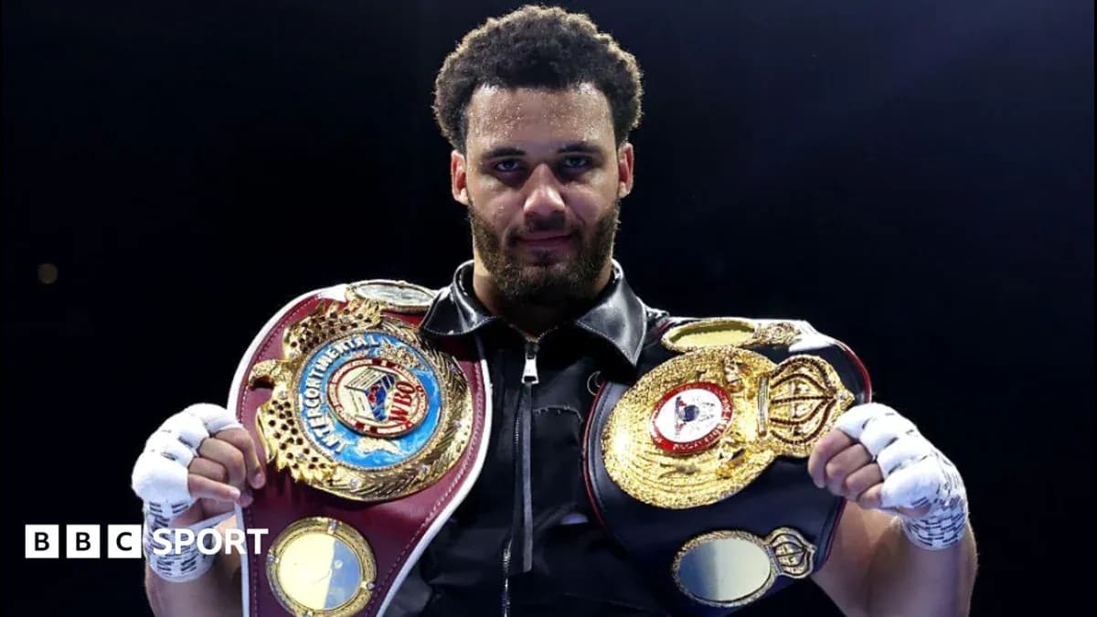 Boxeador sosteniendo dos cinturones de campeonato