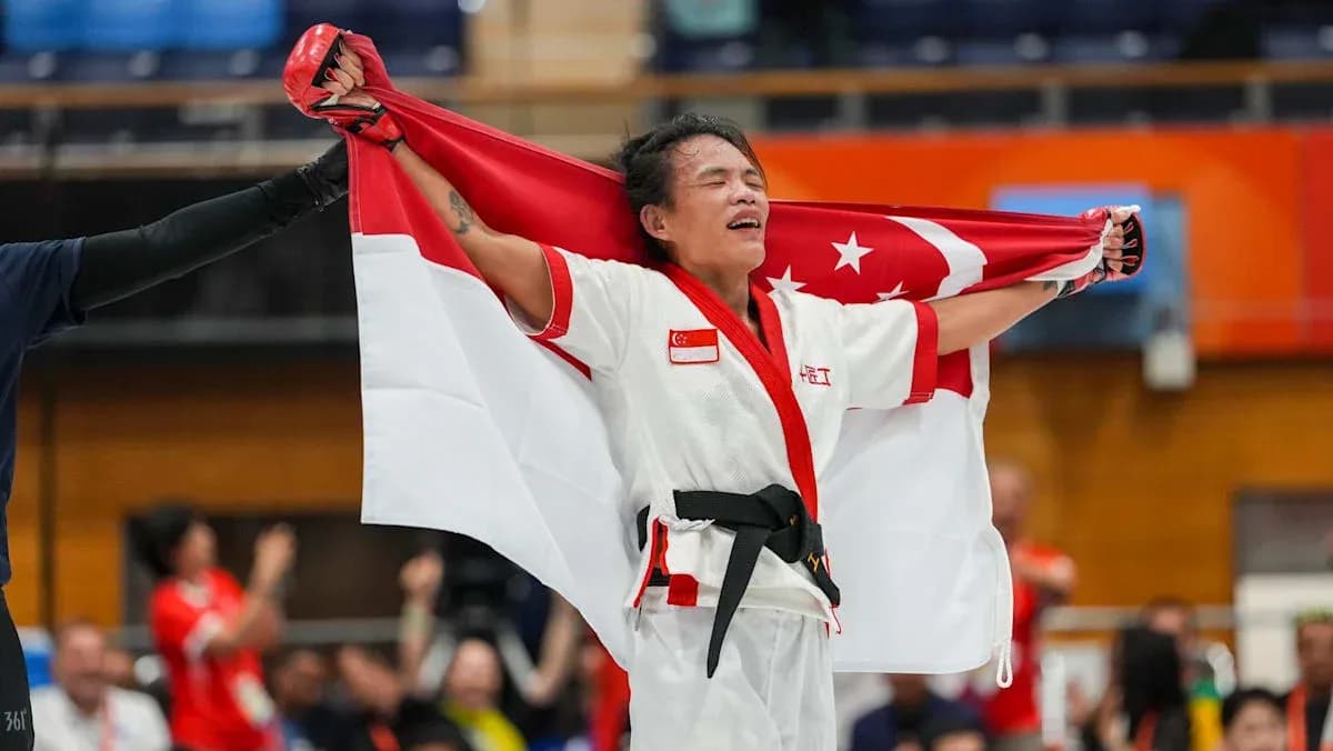 Atleta sosteniendo la bandera de Singapur tras competir