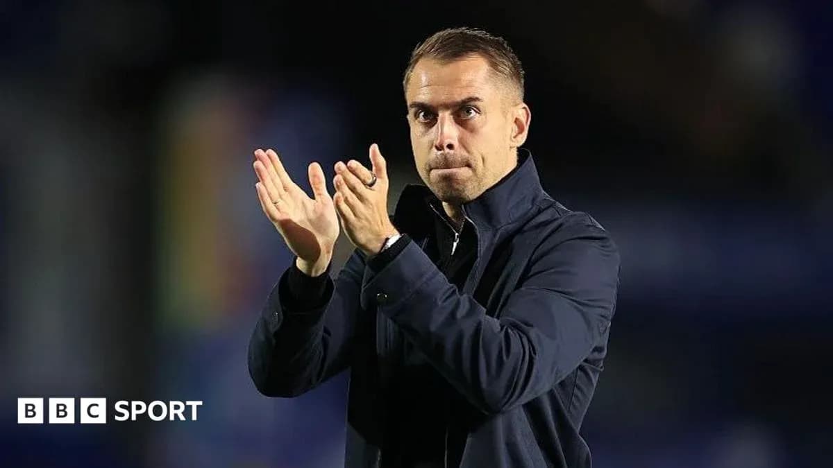 Entrenador aplaudiendo desde la banda del campo
