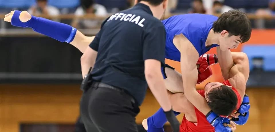 Luchador azul levantando al oponente rojo en combate