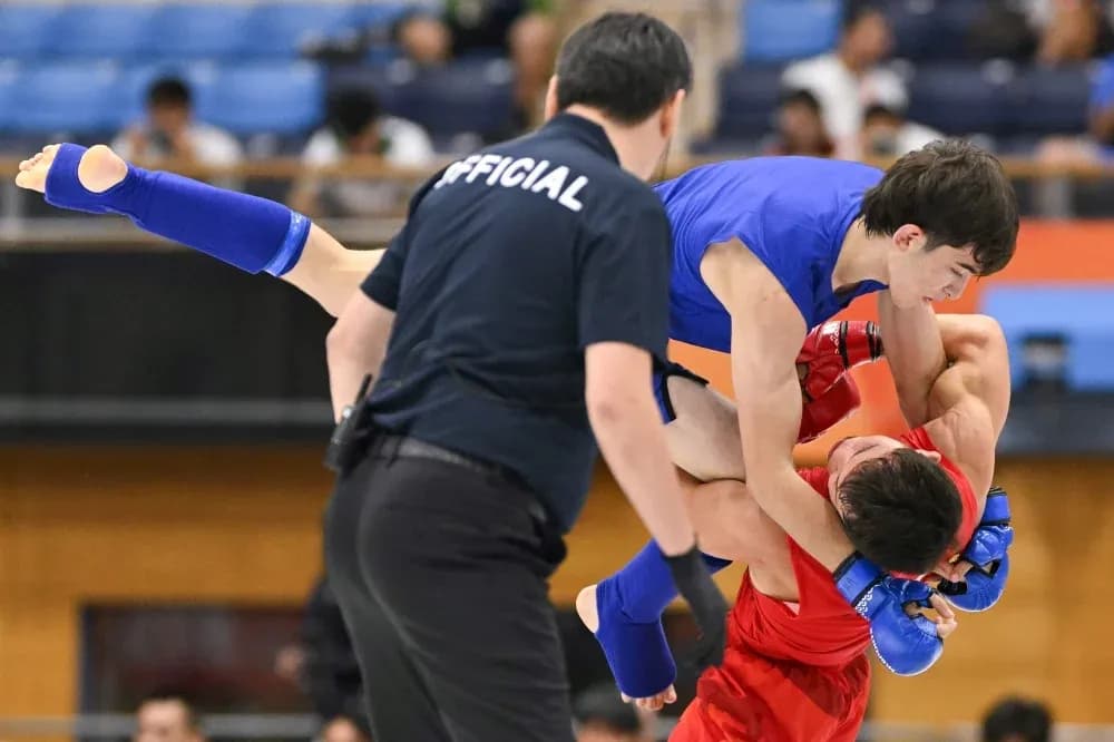 Luchador azul levantando al oponente rojo en combate