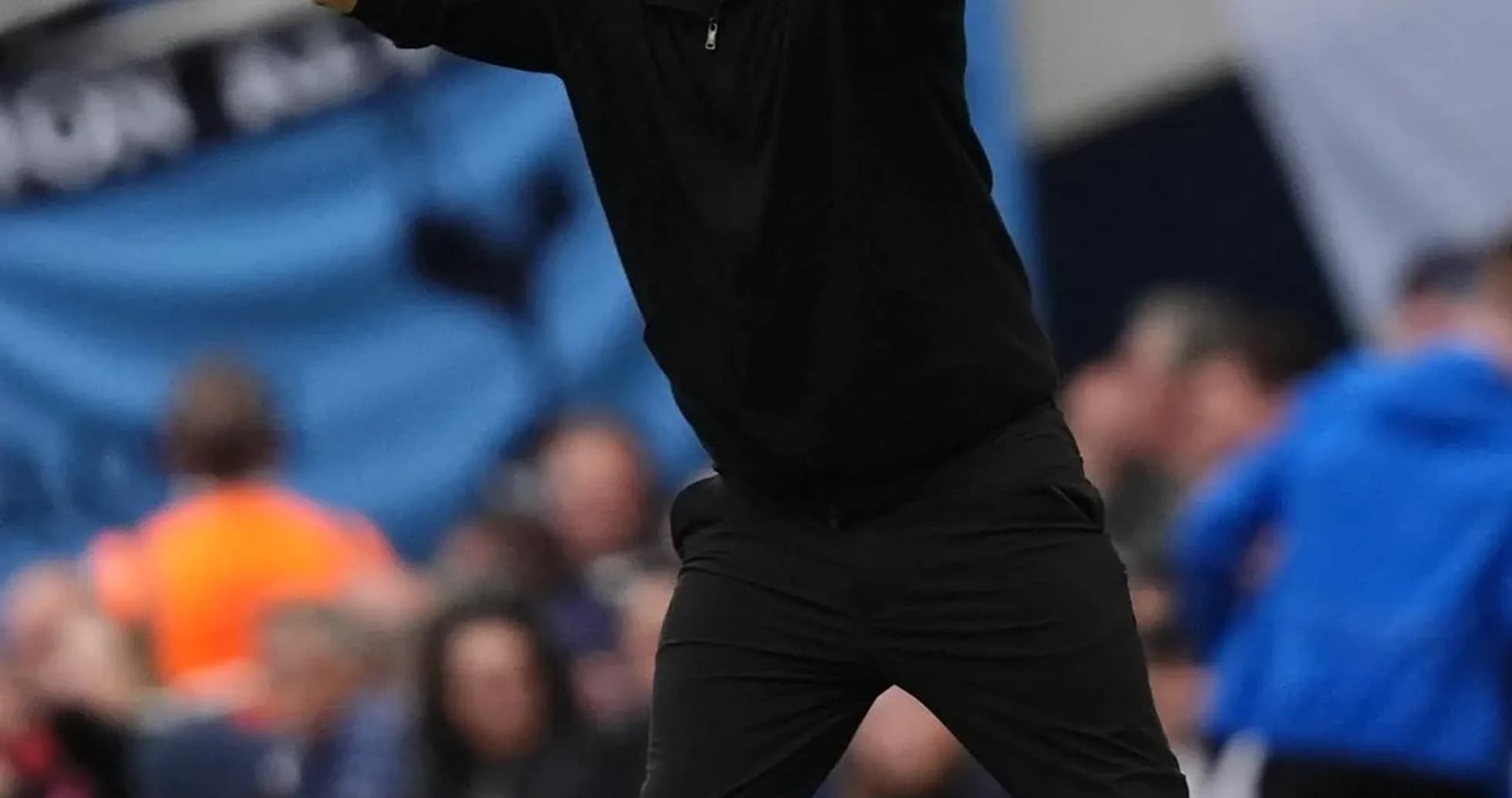 Entrenador gesticulando durante un partido de fútbol