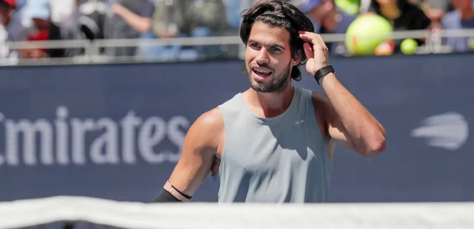 Jugador de tenis ajustándose el cabello durante el partido
