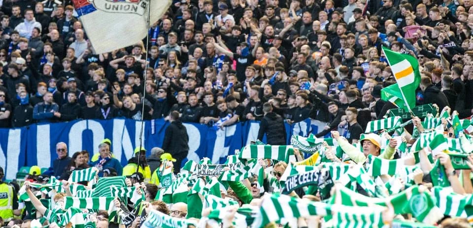 Aficionados agitando bufandas en un partido de fútbol