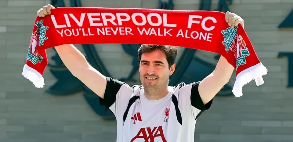 Entrenador sosteniendo bufanda de Liverpool FC