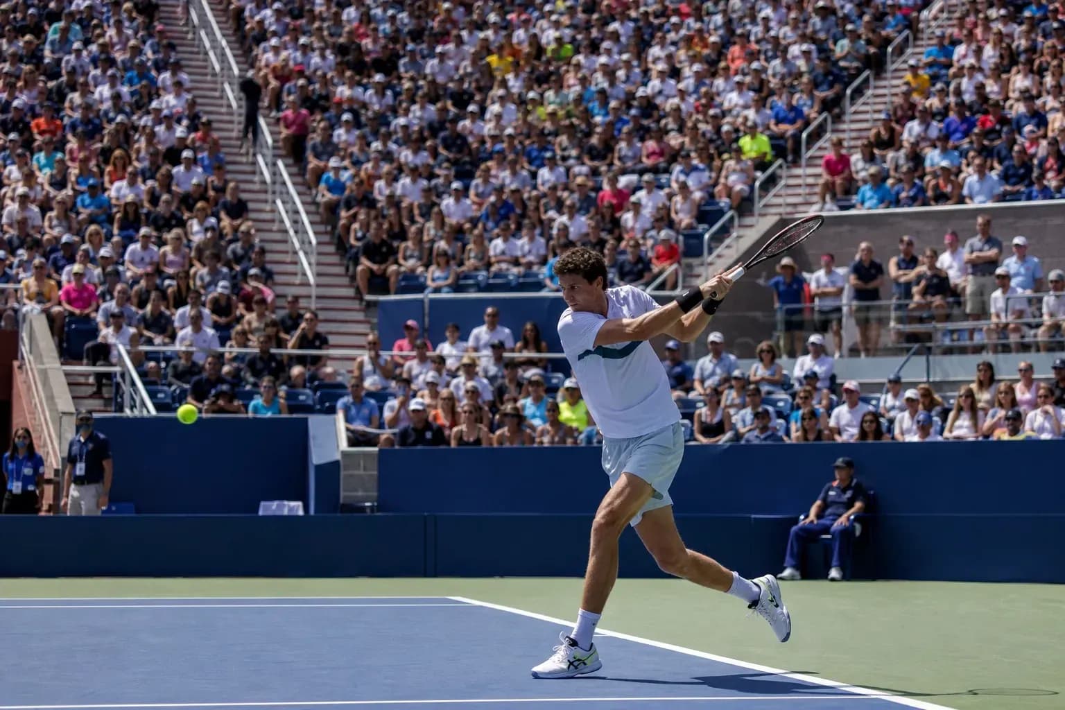 Jugador golpeando una pelota de tenis en el partido