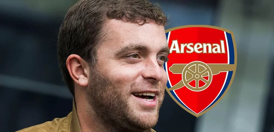 Hombre sonriendo con escudo de Arsenal de fondo
