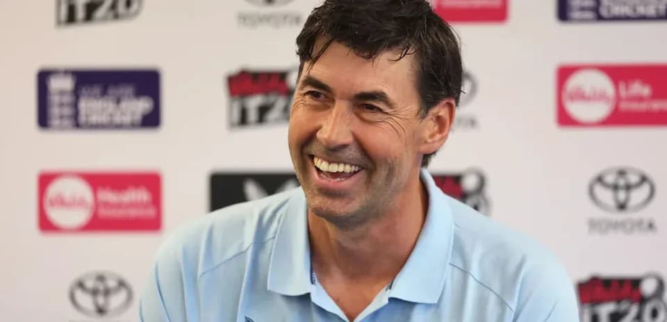 Entrenador sonriendo en conferencia de prensa