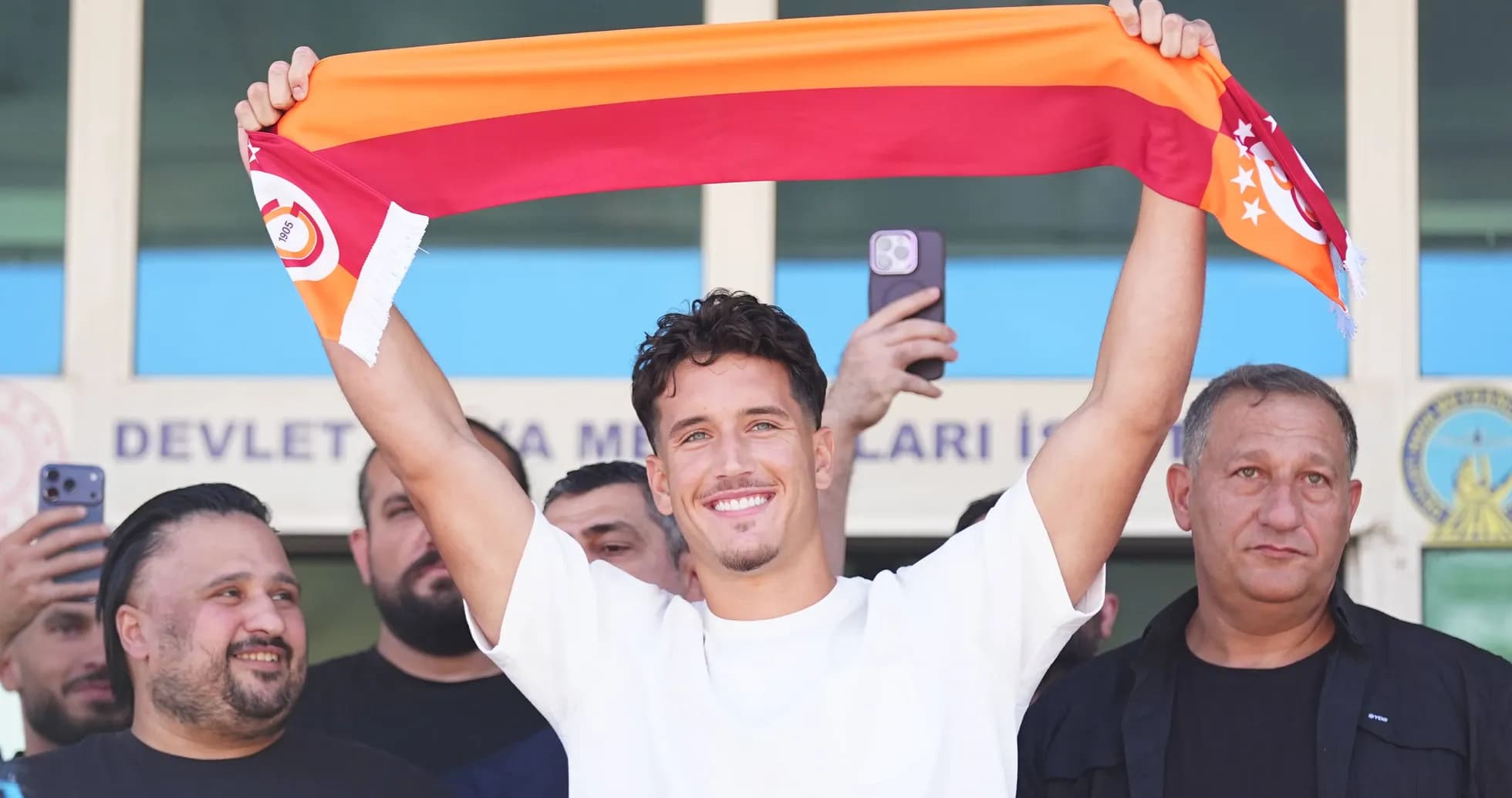 Jugador sosteniendo una bufanda de Galatasaray en presentación