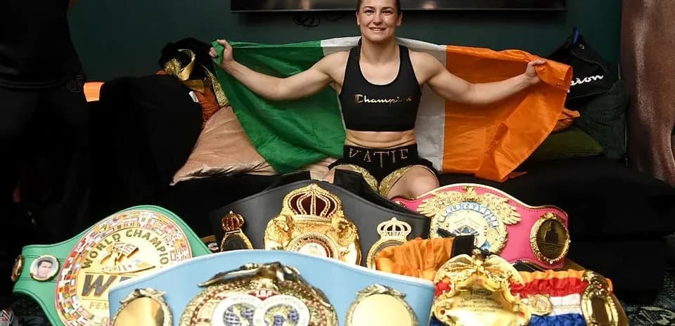 Boxeadora sosteniendo la bandera irlandesa con cinturones