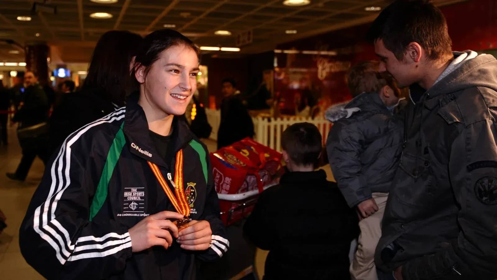 Atleta con medalla sonriendo en aeropuerto
