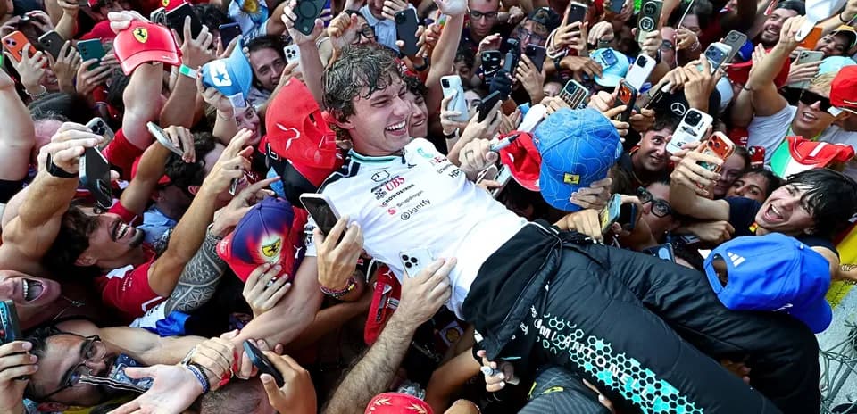 Piloto rodeado de aficionados tras la carrera