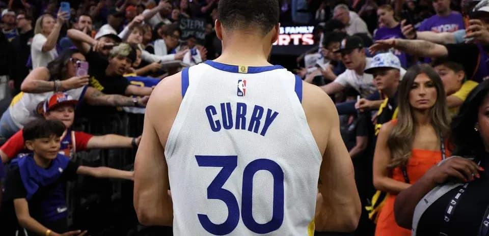 Jugador con camiseta de Curry saluda a la multitud