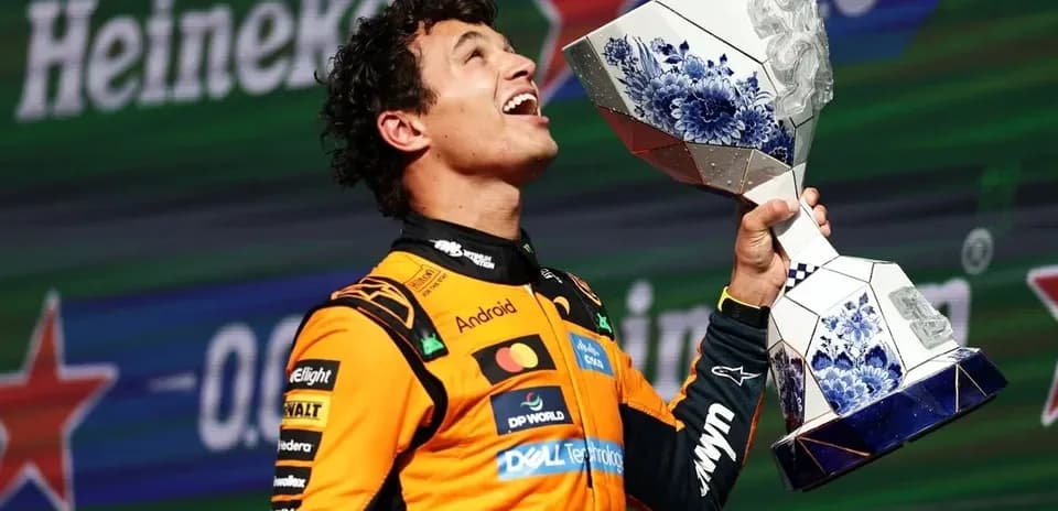 Piloto levantando trofeo en celebración en podio