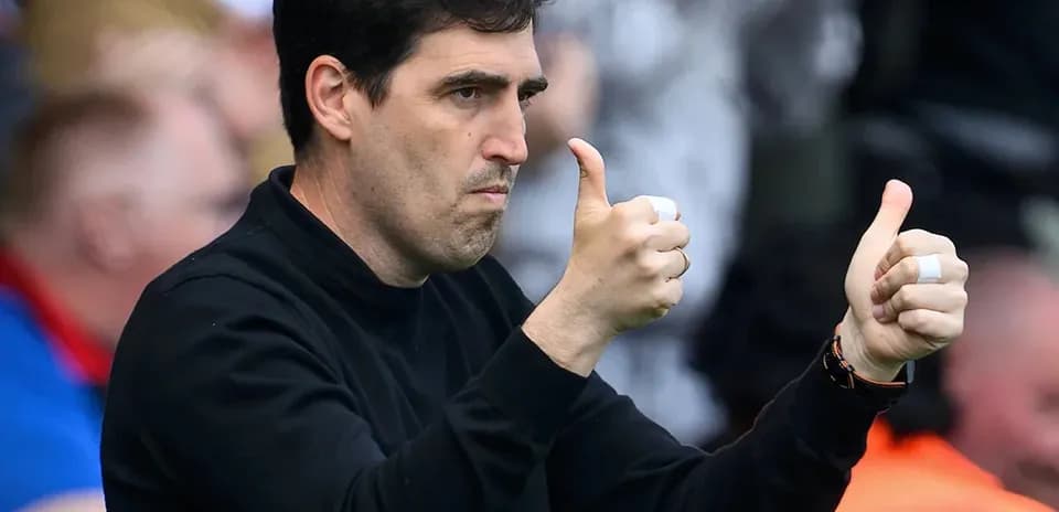 Entrenador mostrando pulgares arriba durante el partido