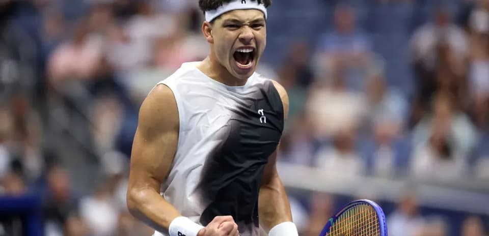 Jugador de tenis celebrando con raqueta en la mano
