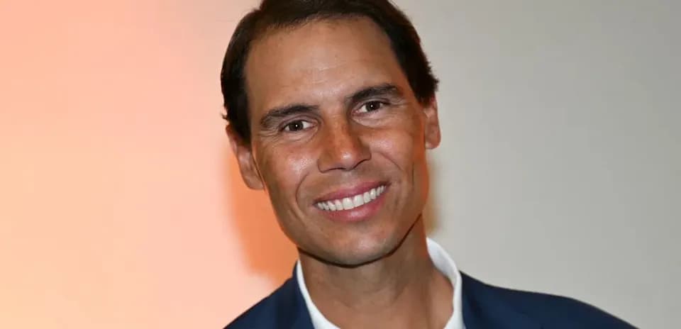 Hombre sonriendo con traje oscuro y fondo claro