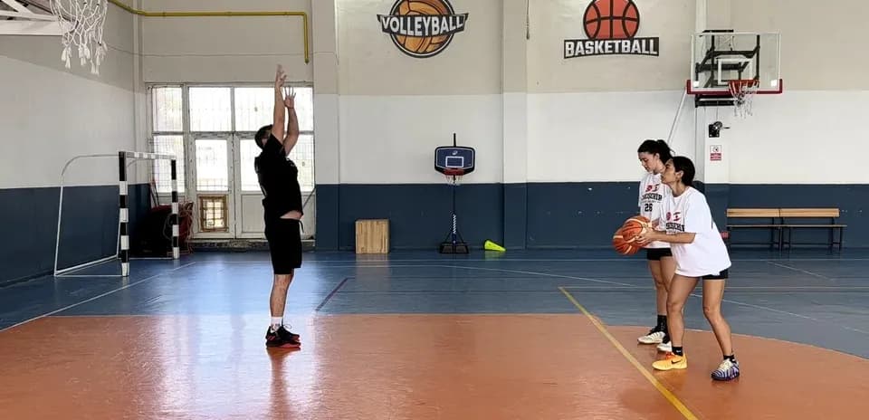 Entrenador enseñando tiro a dos jugadoras de baloncesto