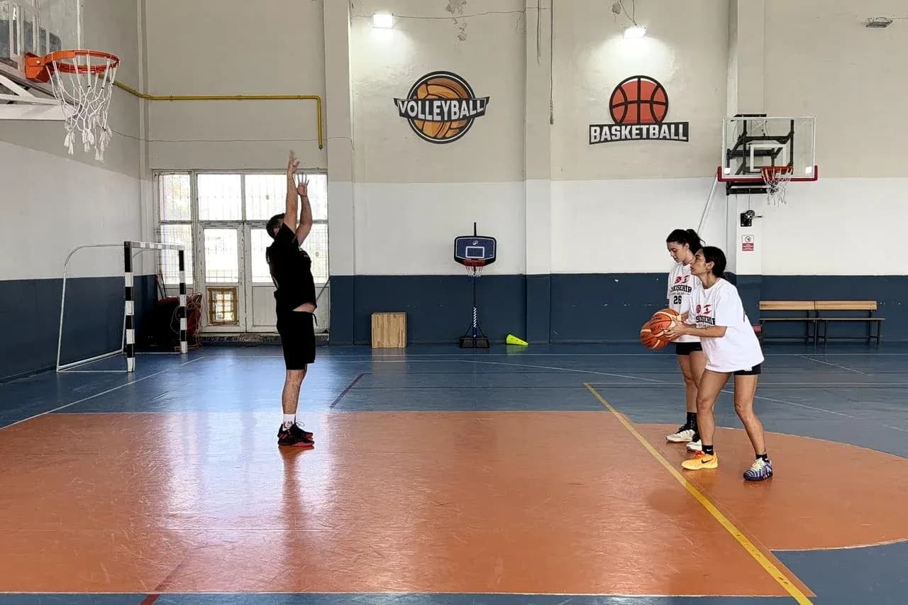 Entrenador enseñando tiro a dos jugadoras de baloncesto