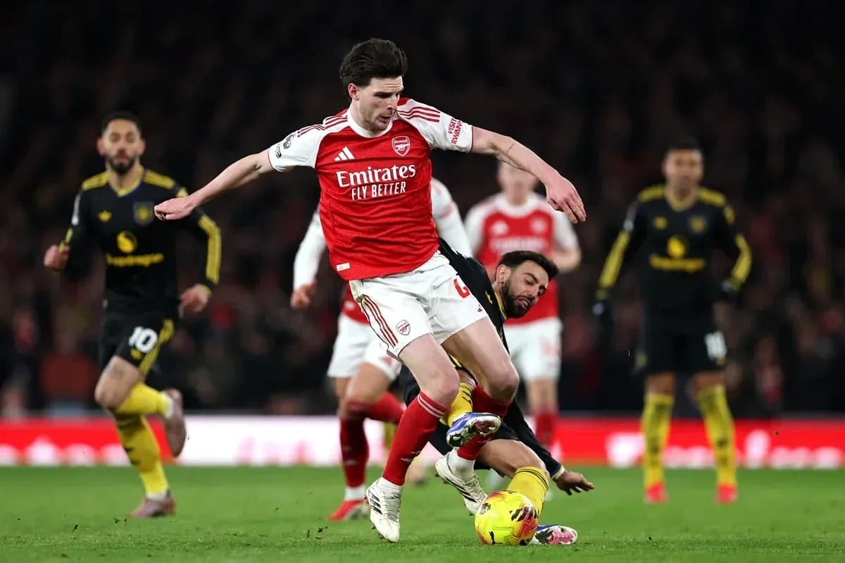 Jugador de Arsenal esquivando a oponente en el suelo