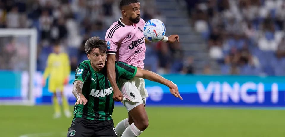 Jugador de Juventus despejando el balón ante adversario