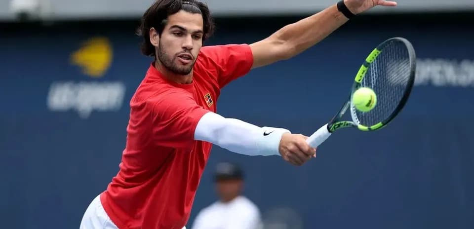 Jugador de tenis golpeando una pelota en entrenamiento