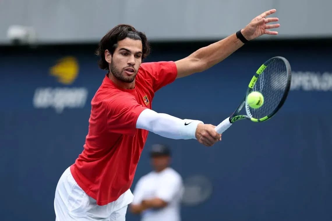 Jugador de tenis golpeando una pelota en entrenamiento