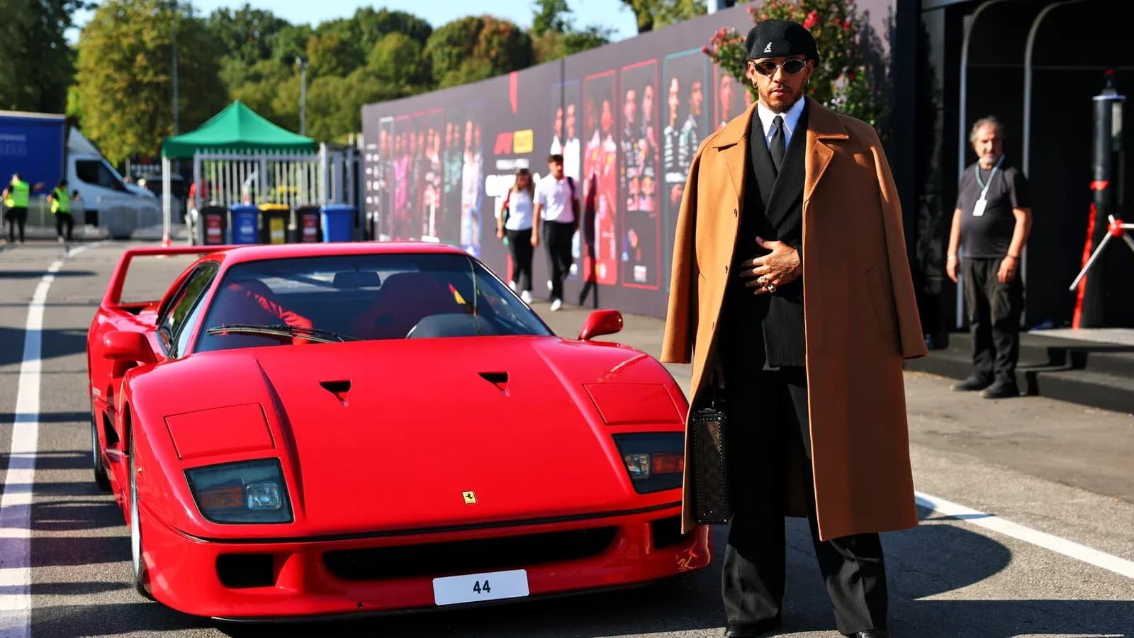 Hombre de pie junto a un Ferrari rojo