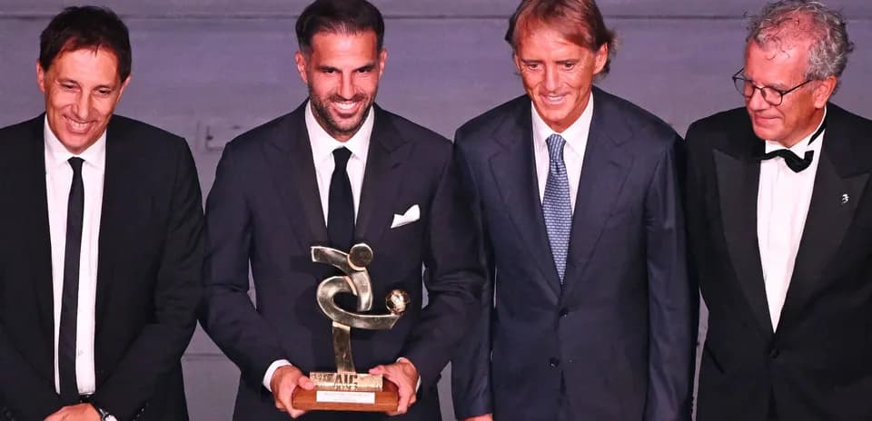 Cuatro hombres en un evento con un trofeo