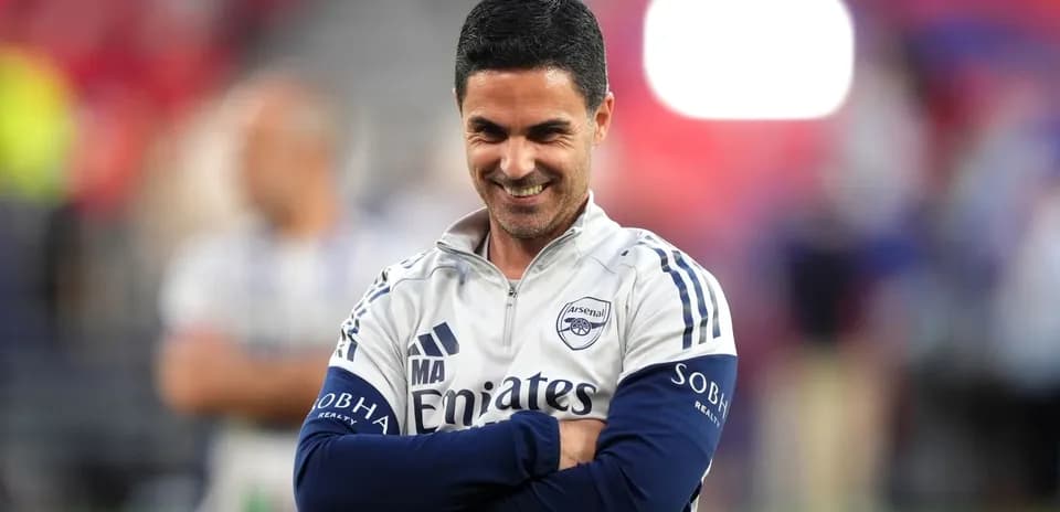 Entrenador de Arsenal en el campo sonriendo