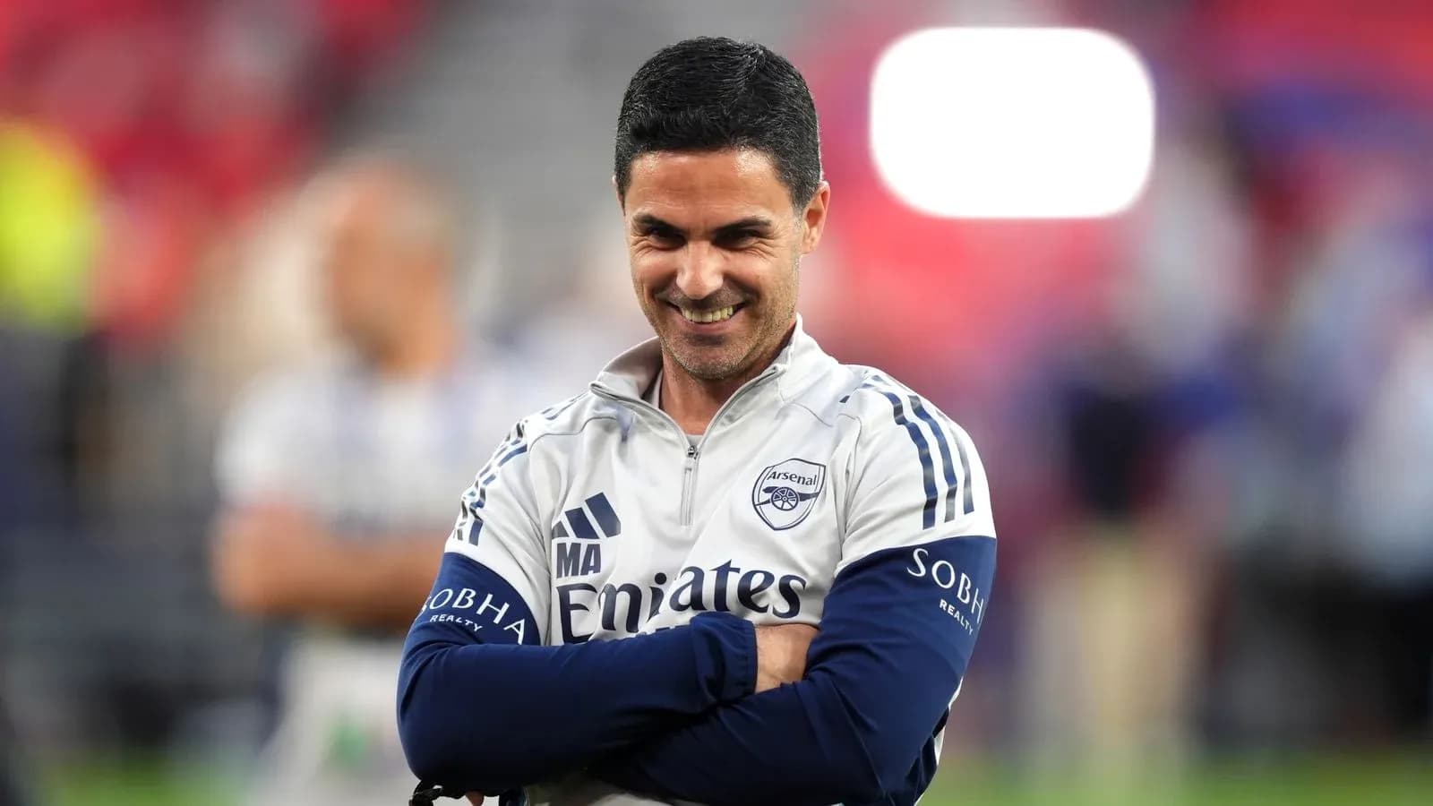 Entrenador de Arsenal en el campo sonriendo