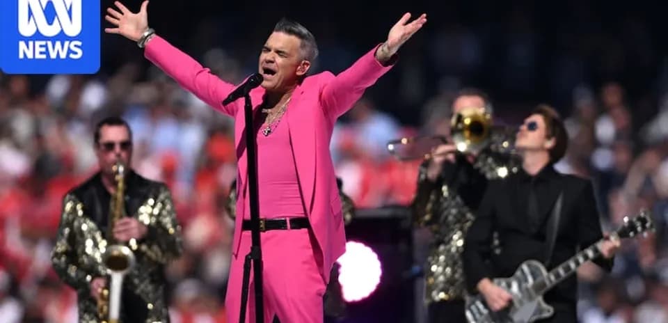Artista en traje rosa cantando con banda en escenario