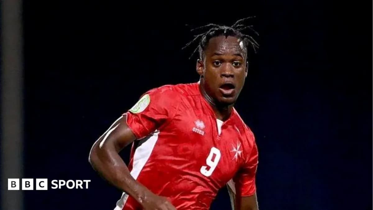 Jugador de fútbol con camiseta roja corriendo en el campo