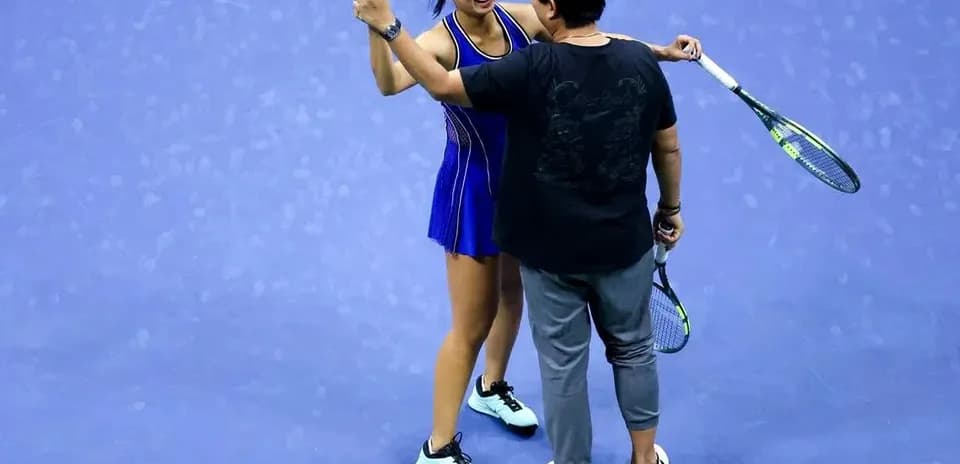Jugadora de tenis celebrando con entrenador en cancha