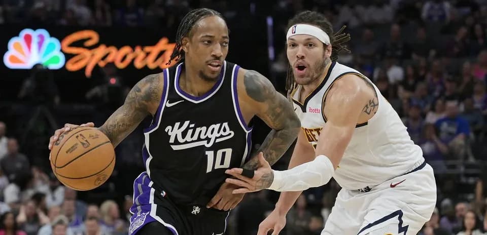 Jugador de Kings driblando ante defensor de Nuggets