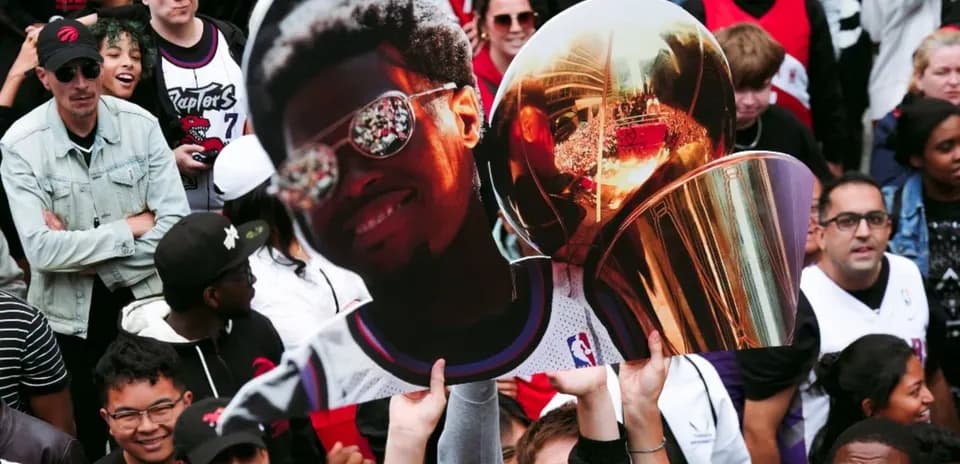 A crowd holding a large cutout of a player