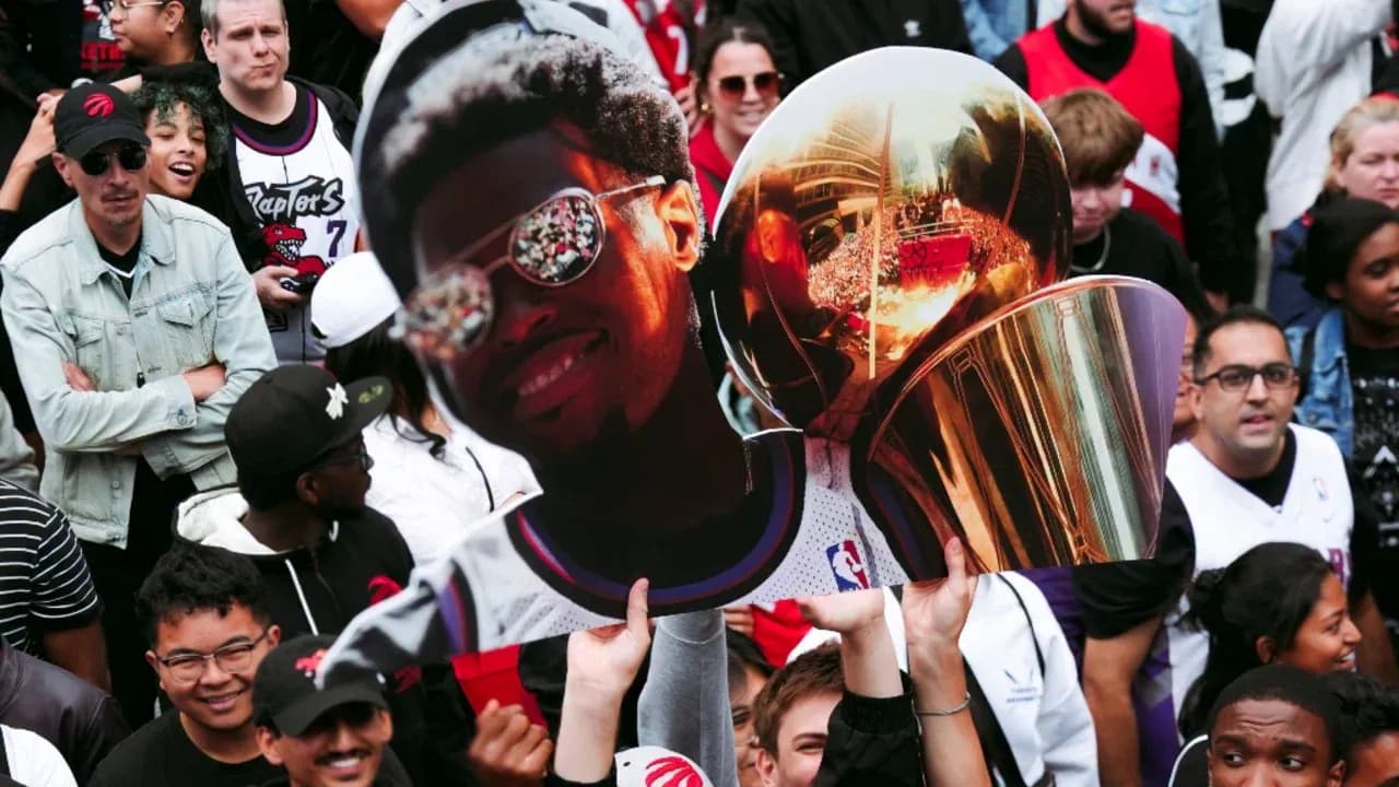 A crowd holding a large cutout of a player