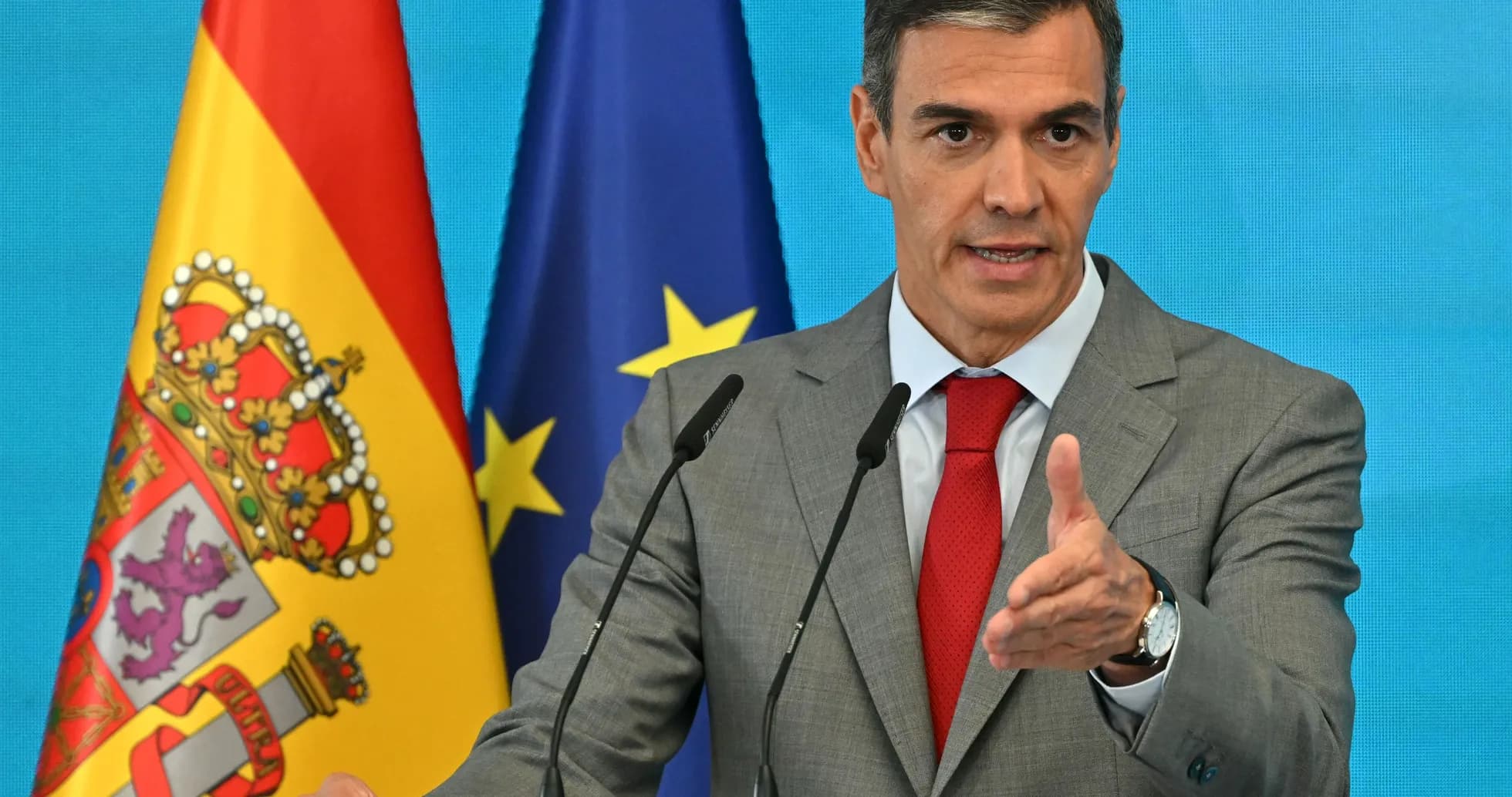 Político hablando en conferencia de prensa con banderas