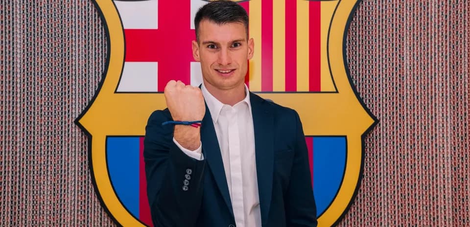 Jugador mostrando el puño frente al escudo del Barcelona