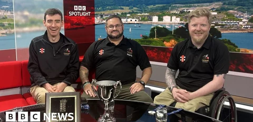 Tres hombres sonrientes en un set de televisión