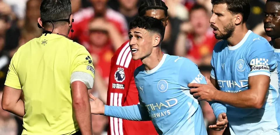 Jugadores de Manchester City discutiendo con el árbitro