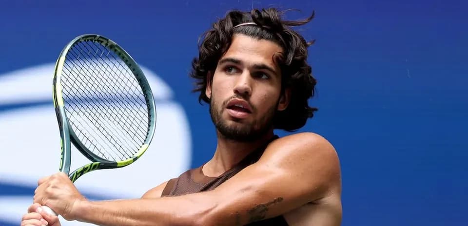 Jugador de tenis preparándose para golpear la pelota