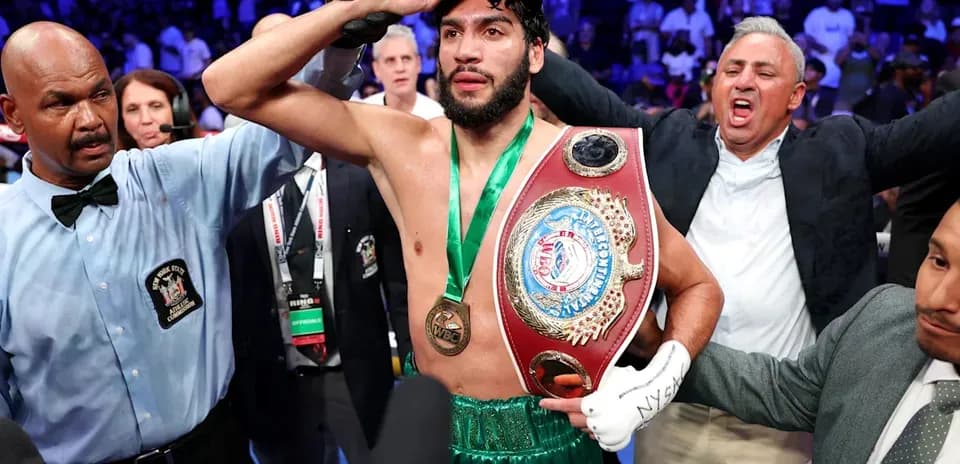 Boxeador sosteniendo cinturón de campeón tras la victoria
