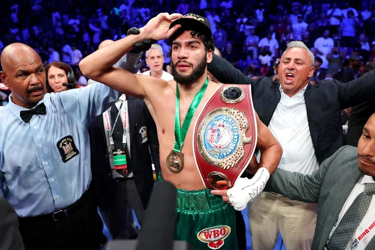 Boxeador sosteniendo cinturón de campeón tras la victoria