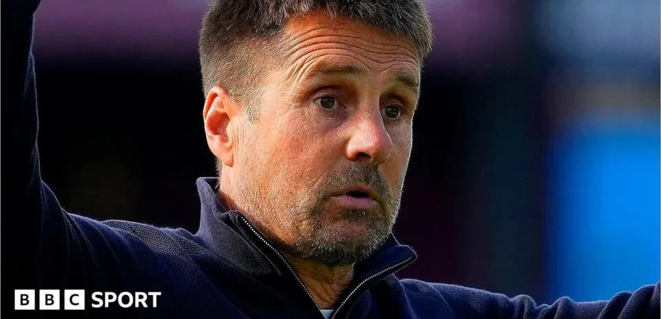Entrenador gesticulando durante un partido de fútbol