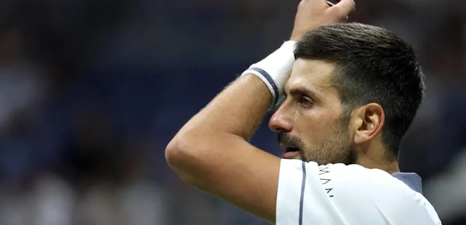 Jugador de tenis con mano en la cabeza durante partido