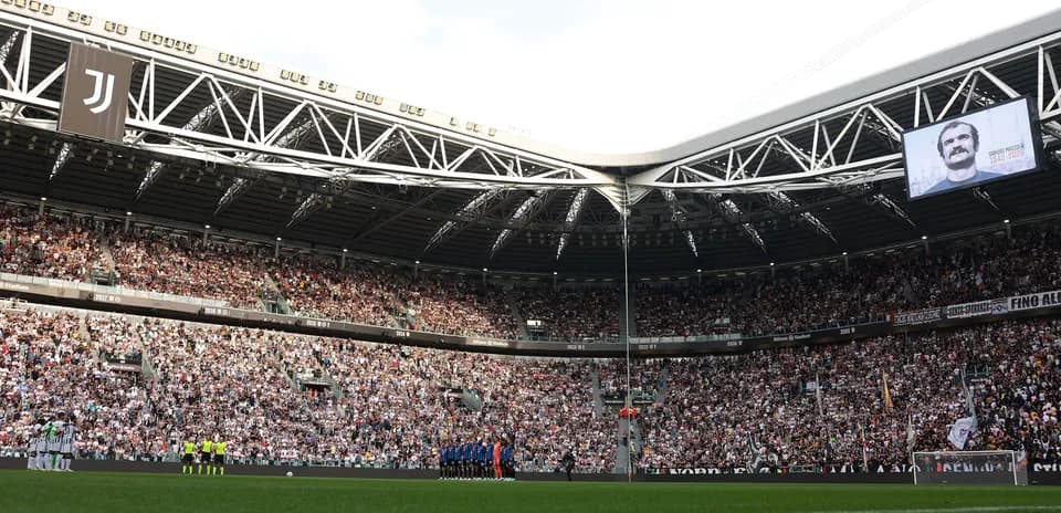Jugadores alineados en el Allianz Stadium lleno de público