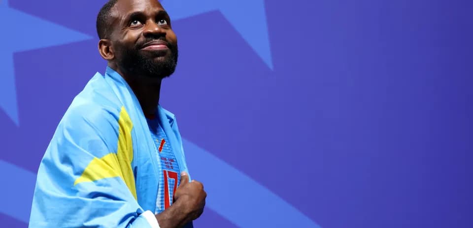 Atleta con bandera sobre los hombros sonriendo
