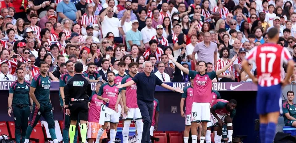 Entrenador gesticulando durante el partido con aficionados
