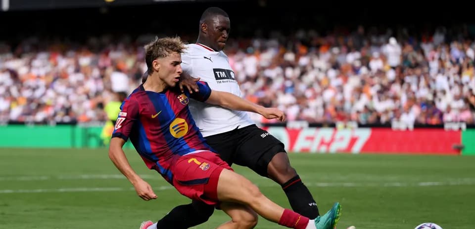 Jugador de Barcelona deslizándose para ganar el balón